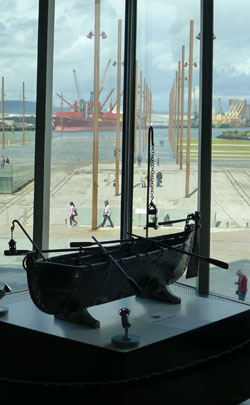 Modell av livbåt på Titanic. I bakgrunden varvets torrdocka.